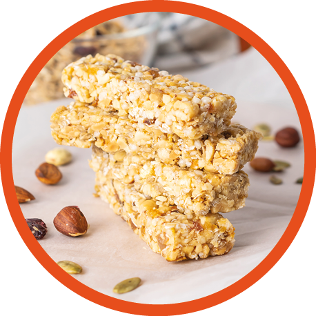 Stack of healthy homemade granola bars with nuts, honey and dried fruit on wooden table in the kitchen
