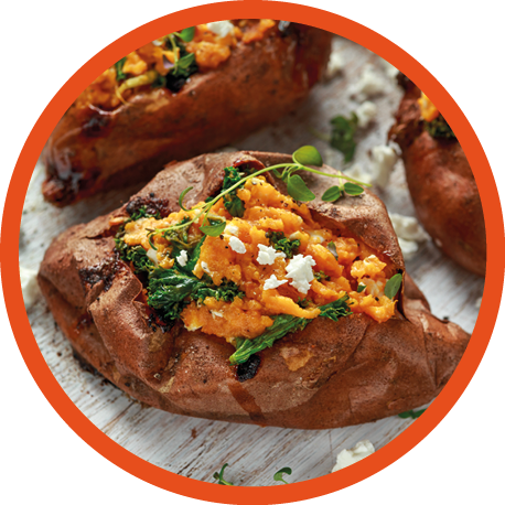 Roast sweet potato stuffed with feta cheese and kale. healthy food.