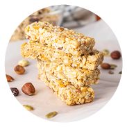 Stack of healthy homemade granola bars with nuts, honey and dried fruit on wooden table in the kitchen
