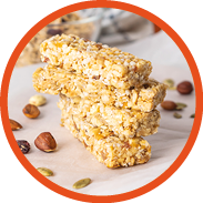 Stack of healthy homemade granola bars with nuts, honey and dried fruit on wooden table in the kitchen