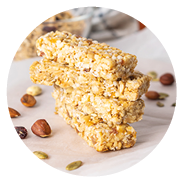 Stack of healthy homemade granola bars with nuts, honey and dried fruit on wooden table in the kitchen